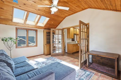 Located right off the kitchen, French doors welcome you into this three season porch, featuring skylights and a sliding glass door to the deck that fills the space with natural light