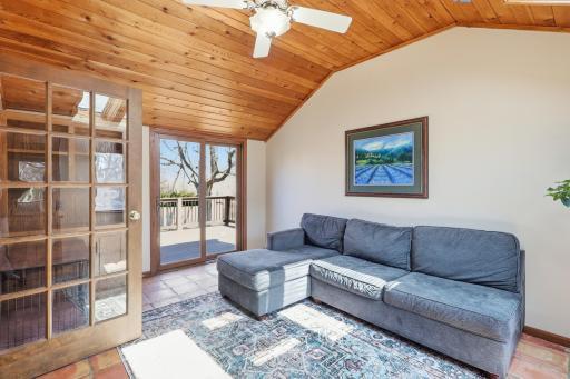 Three season porch just off the kitchen with a sliding glass door to the deck and skylights that bring in an abundance of natural light