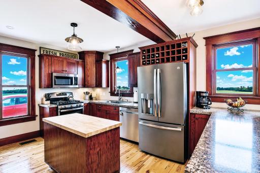 This stunning kitchen boasts custom oak cabinets with a rich cherry stain complemented by warm hickory hardwood flooring. Butcher block island offers the perfect prep area or casual gathering spot.