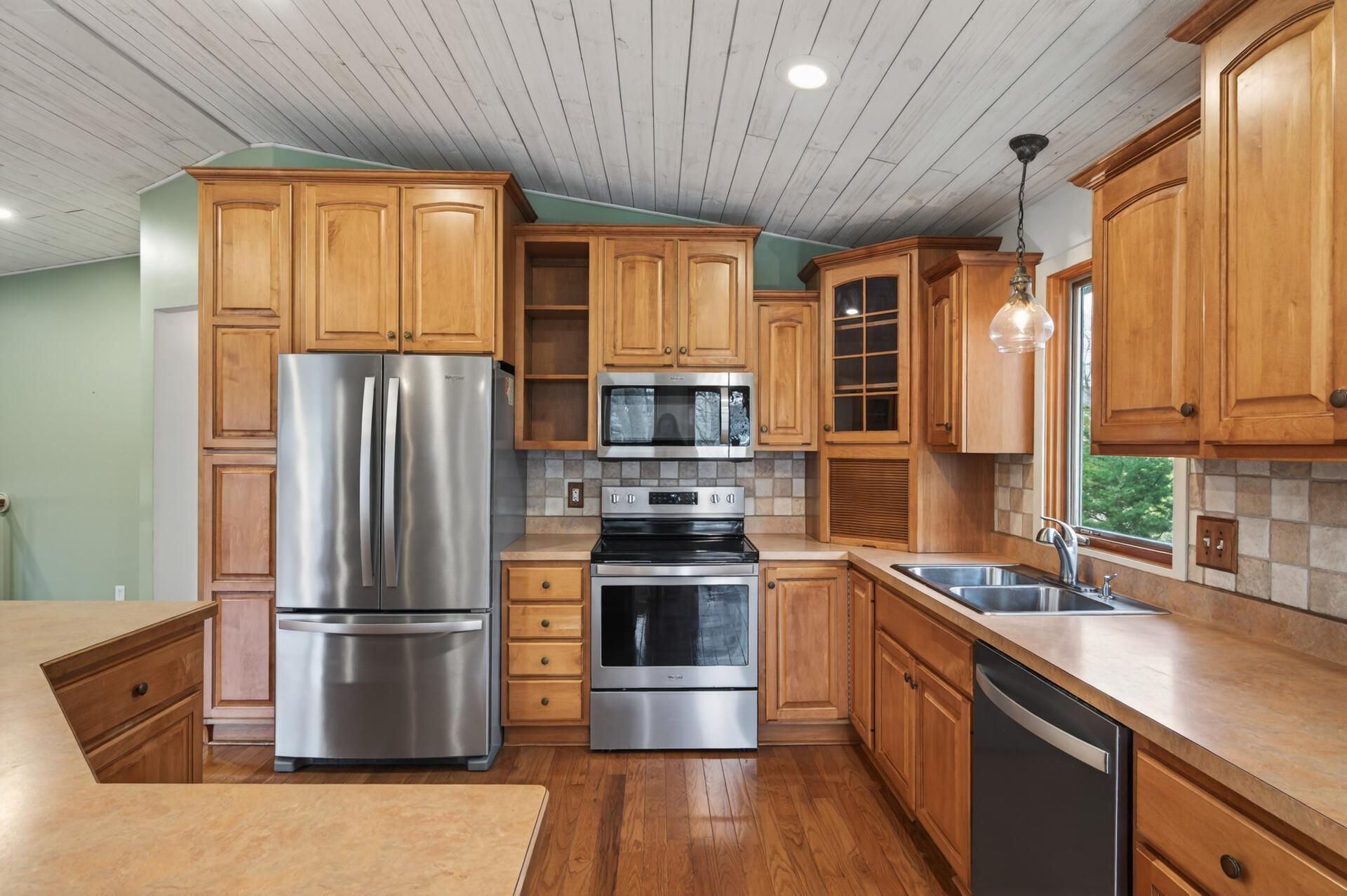 The kitchen features gorgeous maple cabinetry, stainless steel appliances, and a large center island with exceptional storage.
