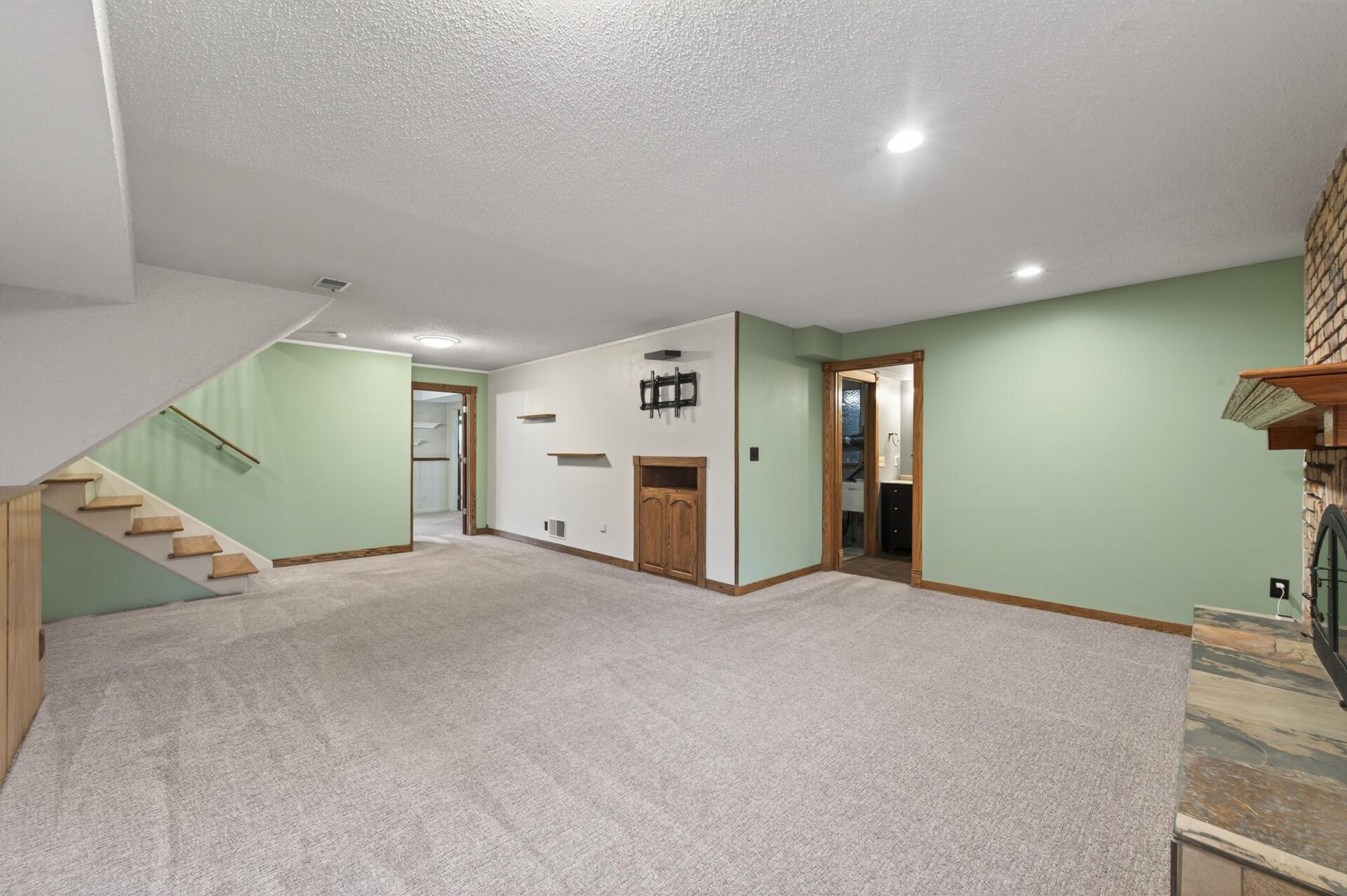 The lower level family room features plush carpeting which offers the perfect place for relaxing, entertaining, or enjoying a cozy night in.