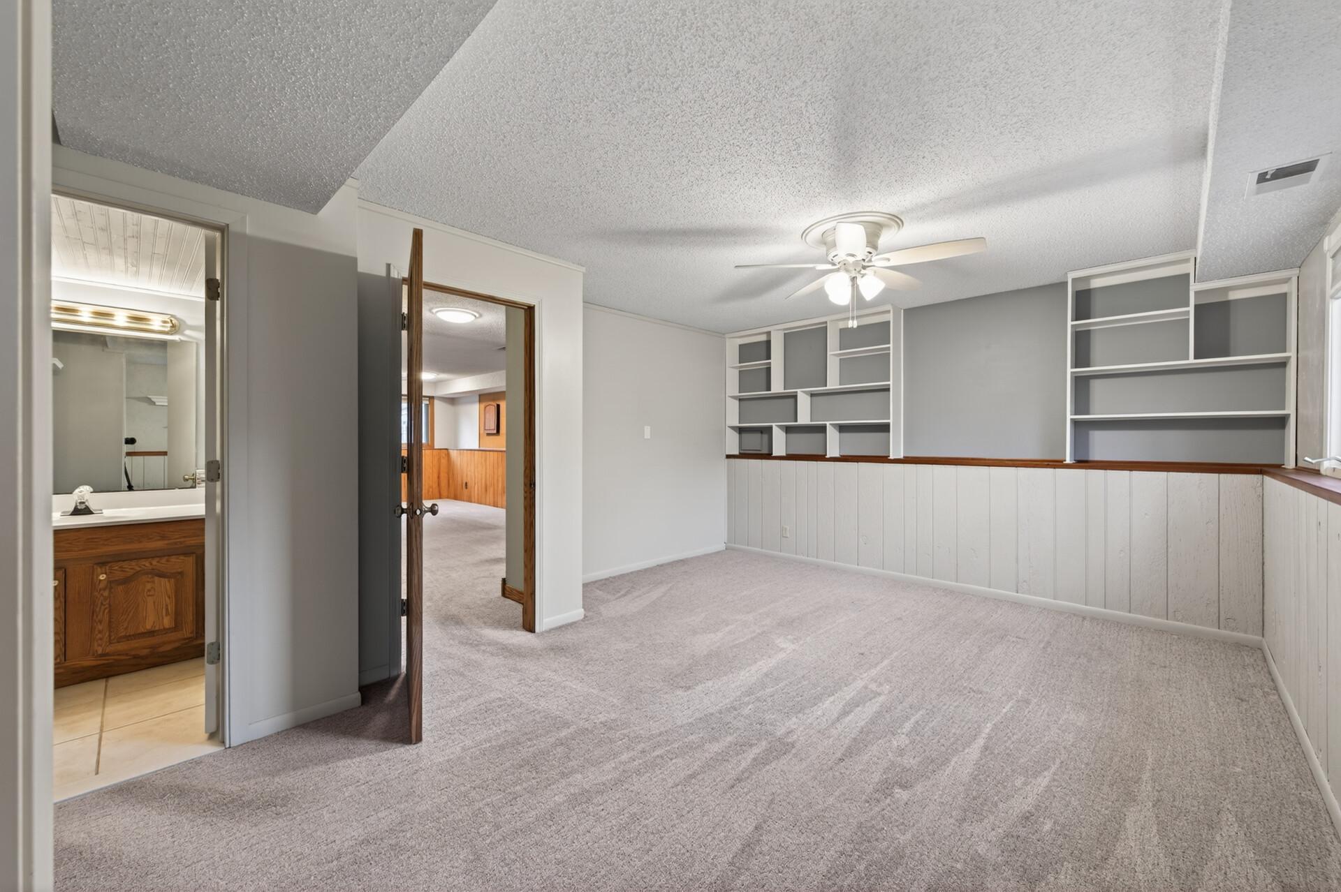 The private, primary suite is located on the lower level and offers plenty of room for a king size bed, end tables, and multiple dressers. The ceiling fan enhances year-round comfort.