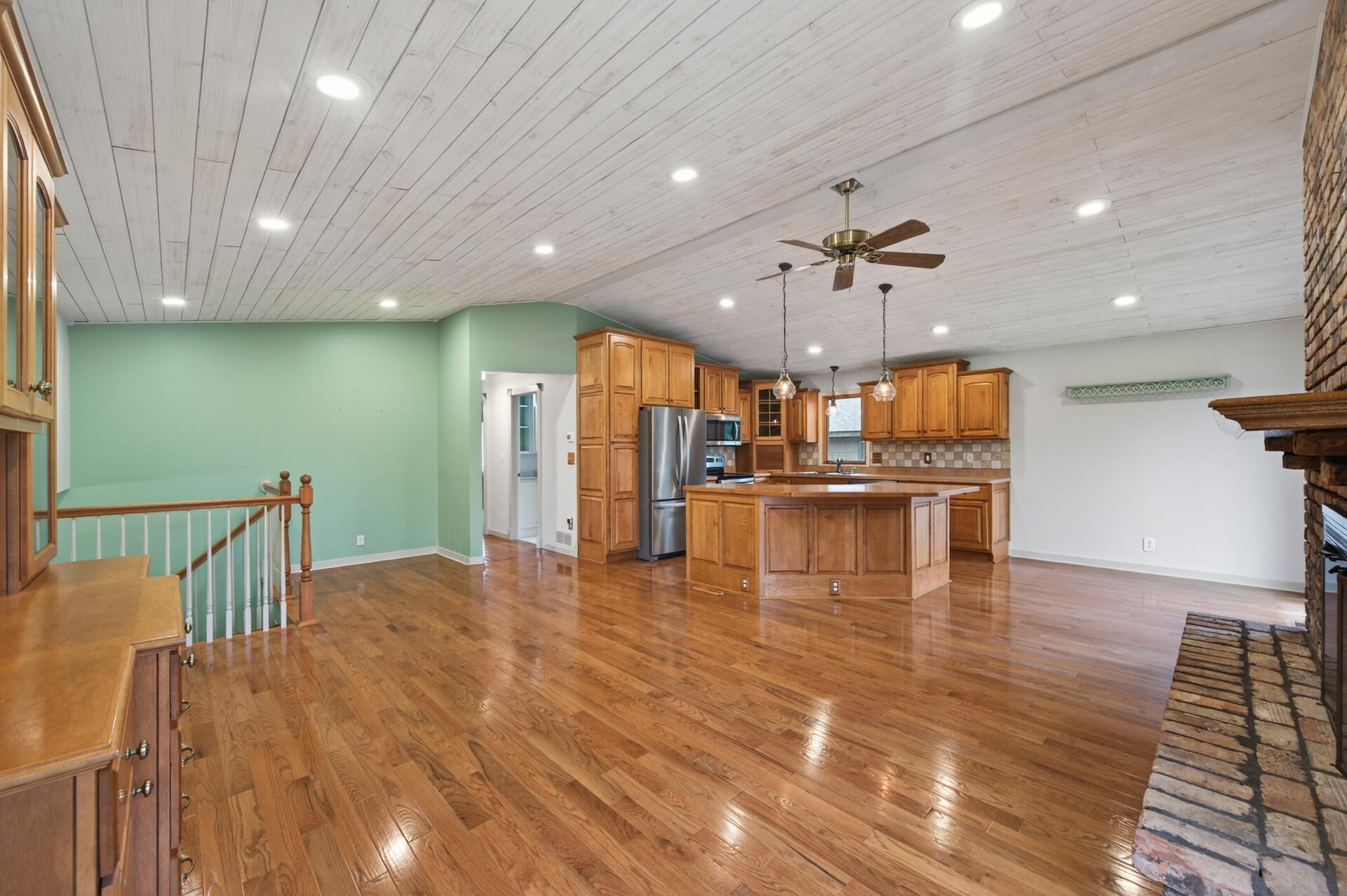 The upper level offers an open-concept floor plan with recessed lighting and a ceiling fan for year-round comfort.