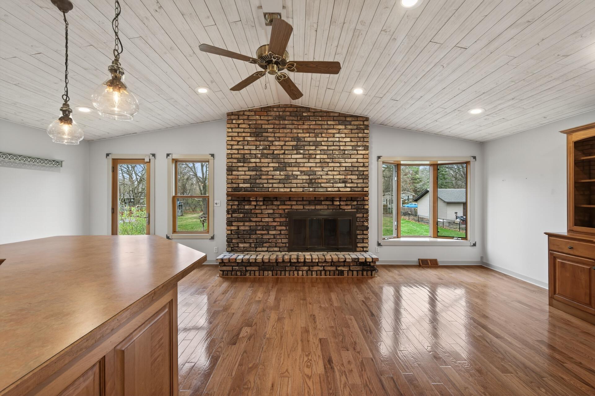The upper level features a cozy wood burning fireplace that serves as a warm and inviting focal point. The fireplace is topped with a classic mantel.