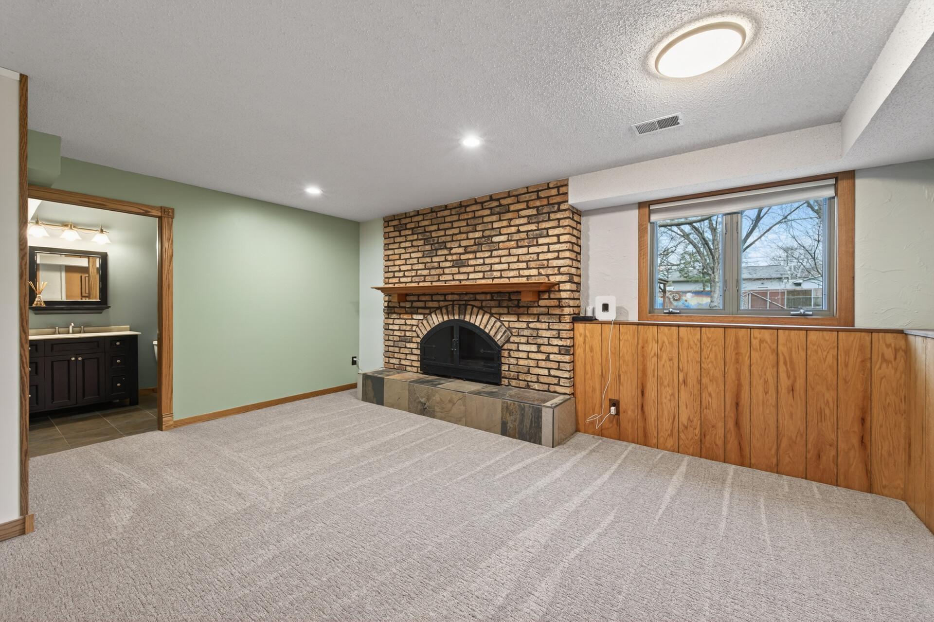 A charming wood burning fireplace fills the lower level family room with warmth and creates a cozy, inviting ambiance.