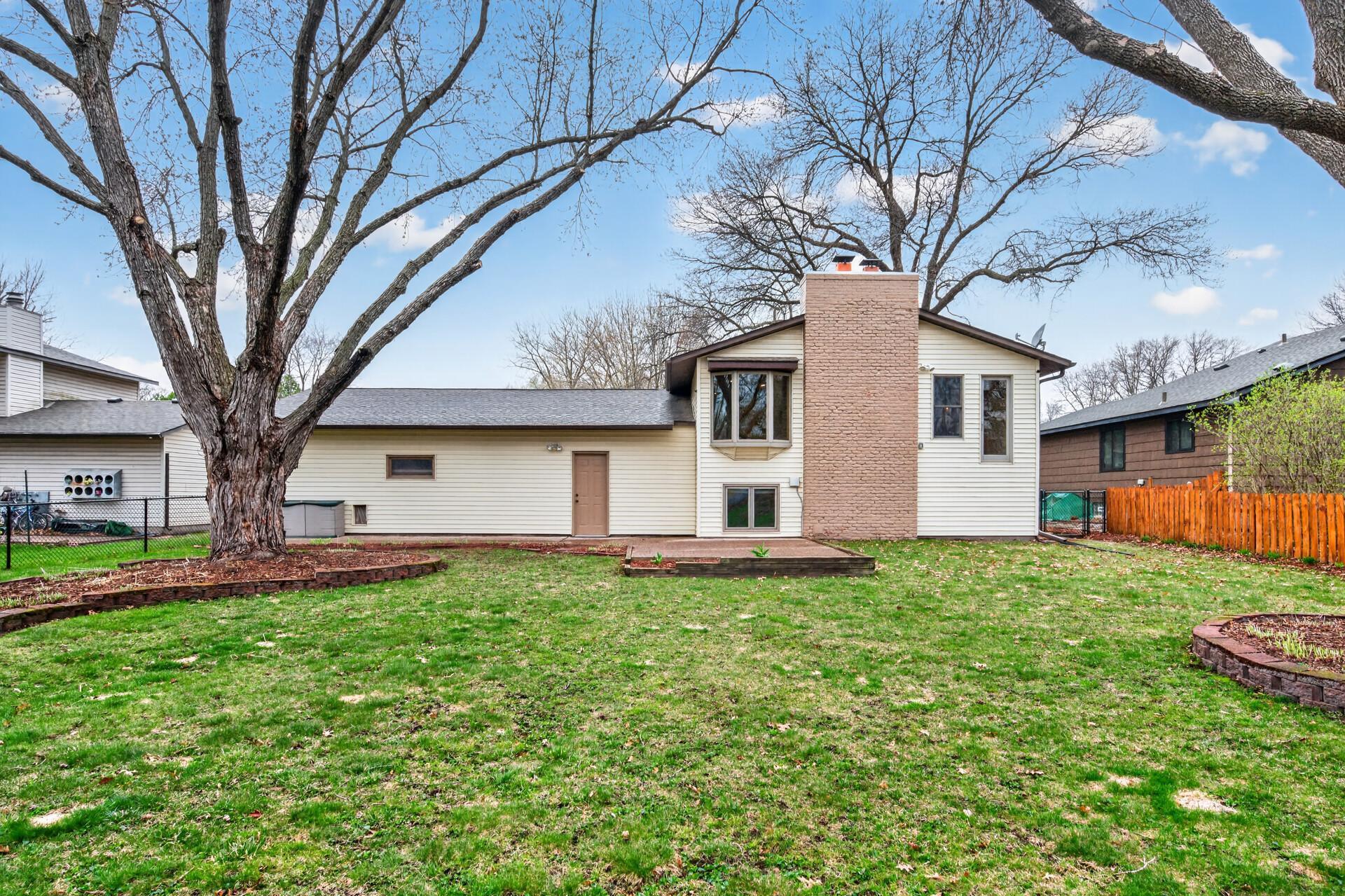 The expansive backyard offers a beautiful blend of space and charm, featuring lush perennial gardens filled with hostas and vibrant lily plants that return year after year.