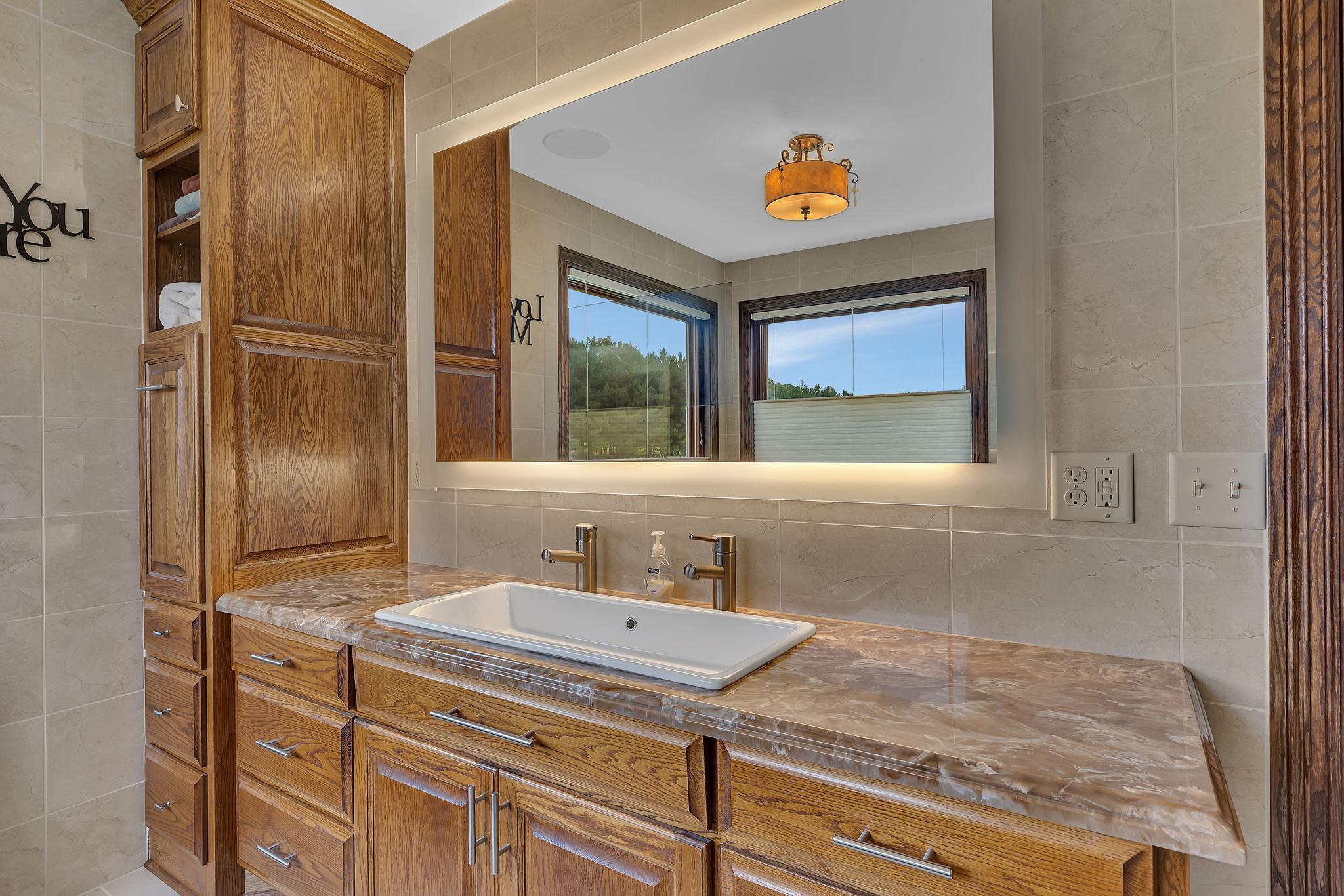 Master bath with solid surface counter, mirror with tv in it and recently remodeled