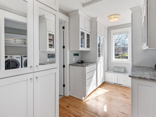Primary Walk-In closet with custom cabinetry connects to dedicated Laundry Room.