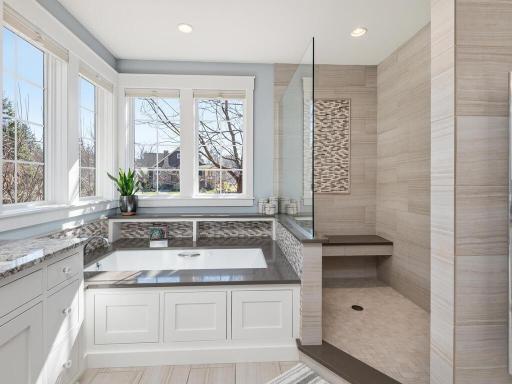 Beautifully tiled step-in shower, jetted tub, and towel warmer - proper finishes for this bath.