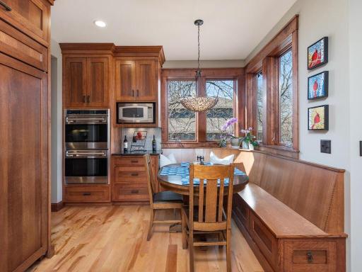 Custom breakfast nook with wall ovens and additional storage.