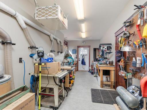 Lower Level Workshop has wall-mounted dust collection system, utility sink, and exterior access door.