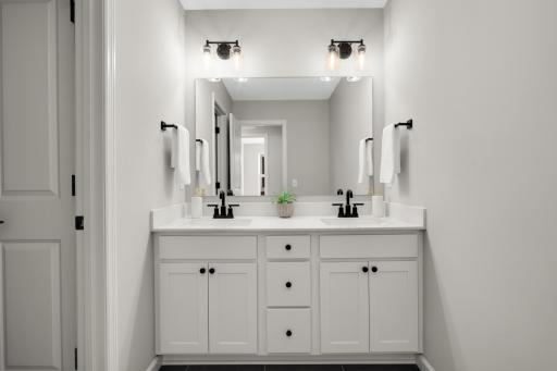 Double sinks in the hallway bathroom. The sink/vanity area is separated from the toilet and tub/shower with a pocket door.