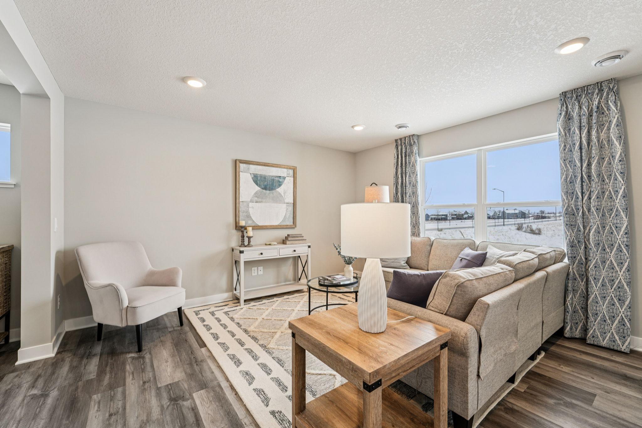 At the end of day, the living room provides a great space to kick up your feet and relax. Photo of model home, color & options will vary.