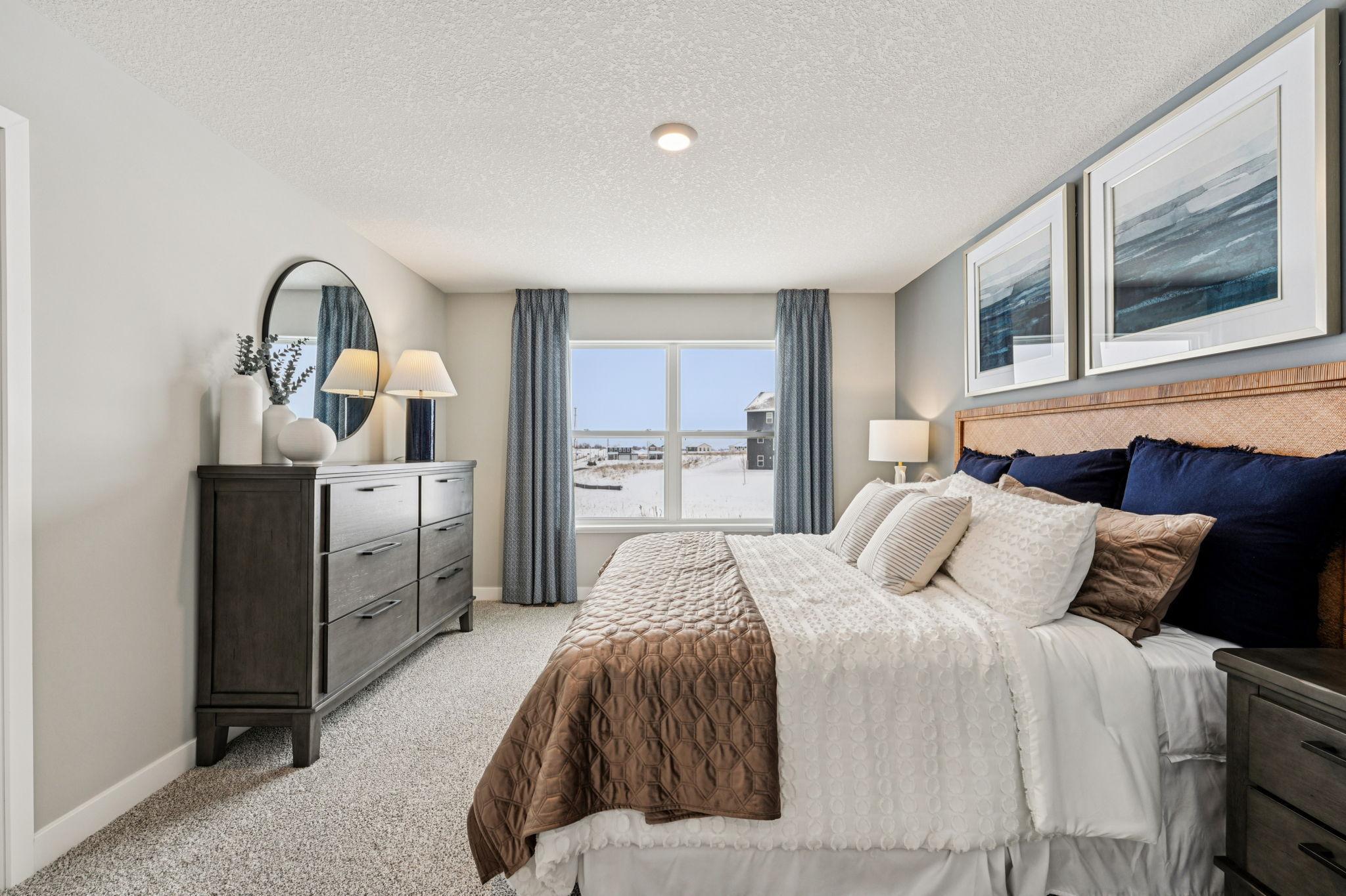 Beautiful primary bedroom upstairs with private ensuite bathroom and walk-in closet. Photo of model home, color & options will vary.