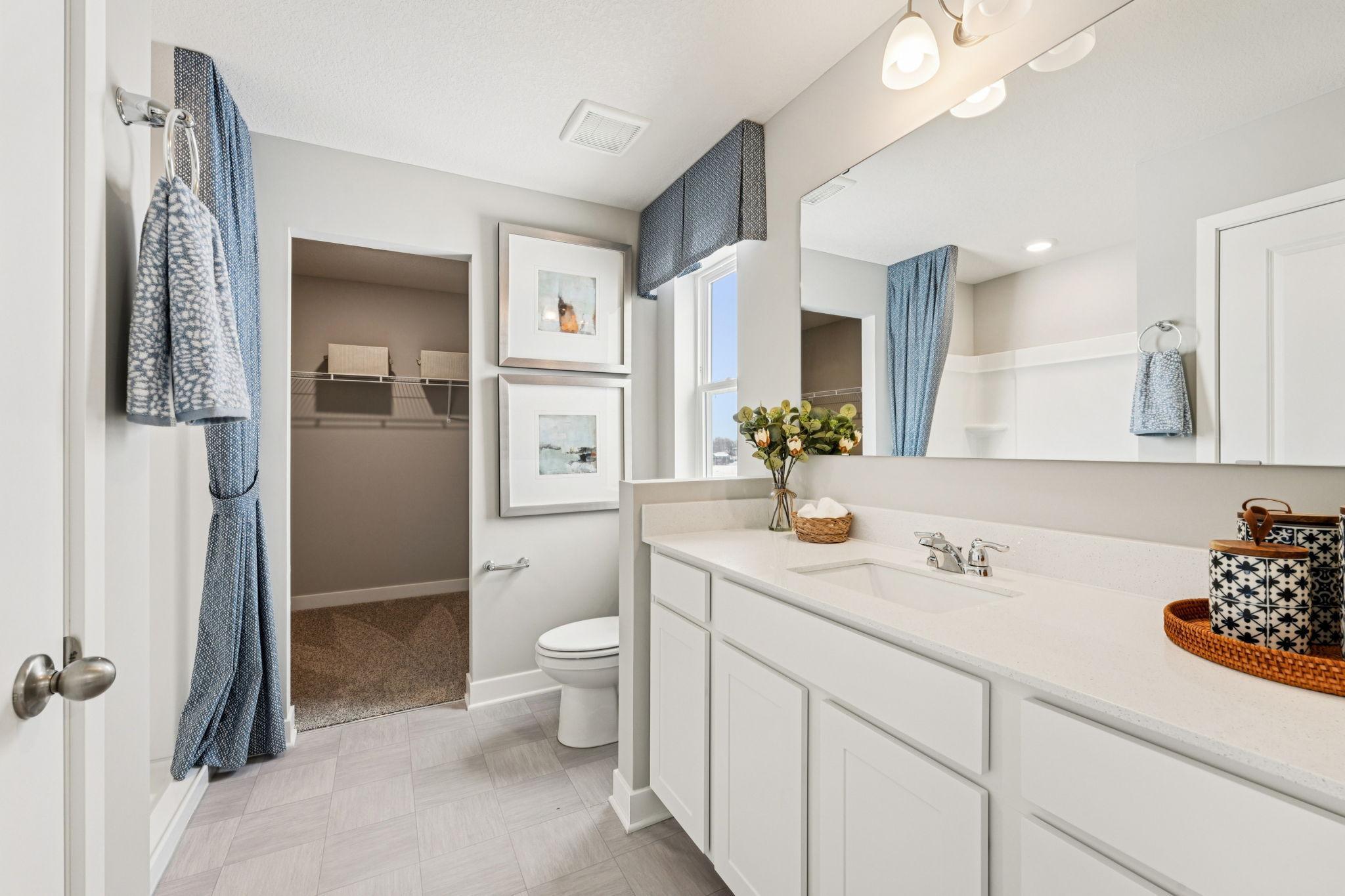 Private ensuite bathroom off primary with walk-in shower. Photo of model home, color & options will vary.