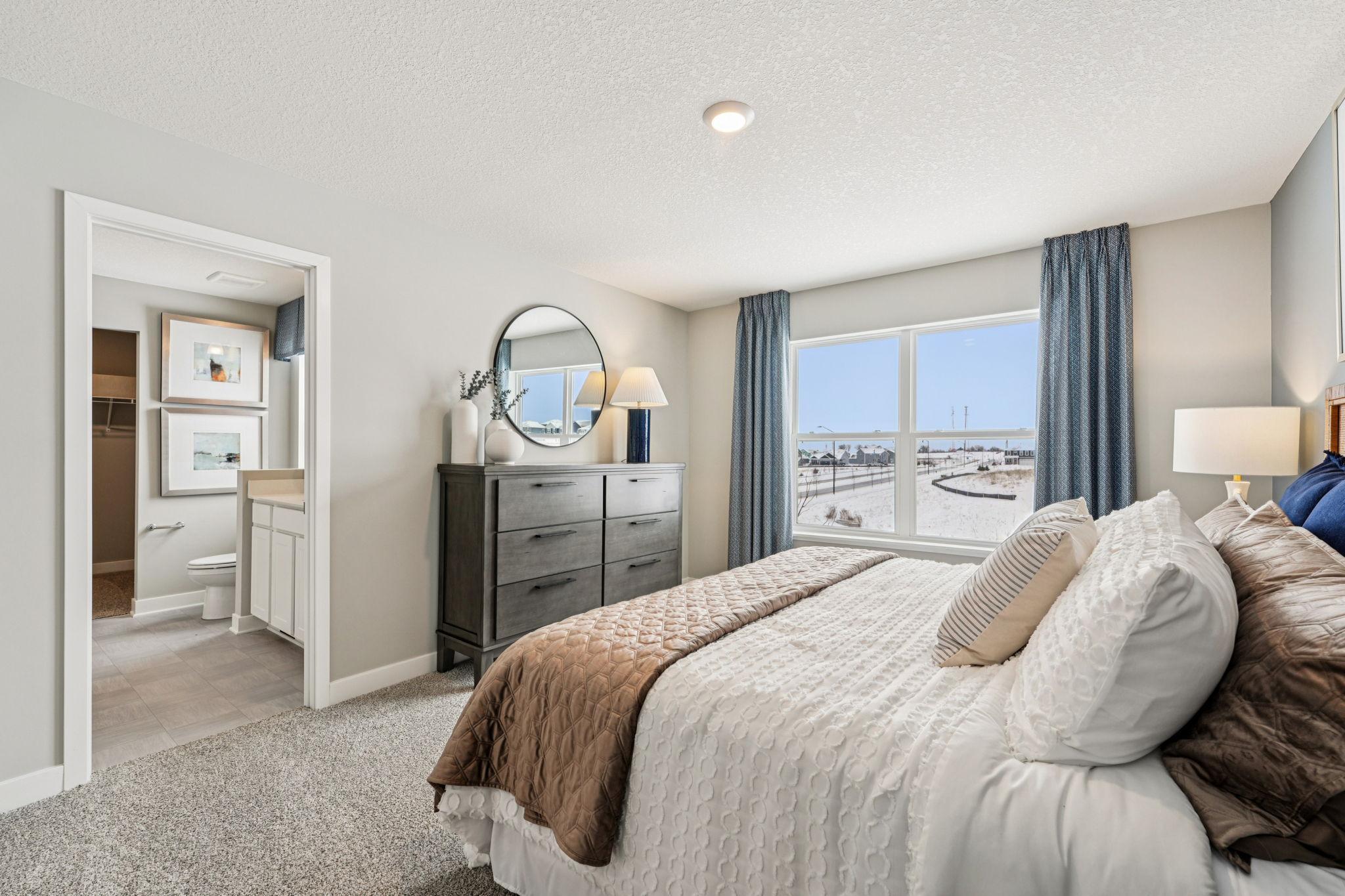 Beautiful primary bedroom upstairs with private ensuite bathroom and walk-in closet. Photo of model home, color & options will vary.