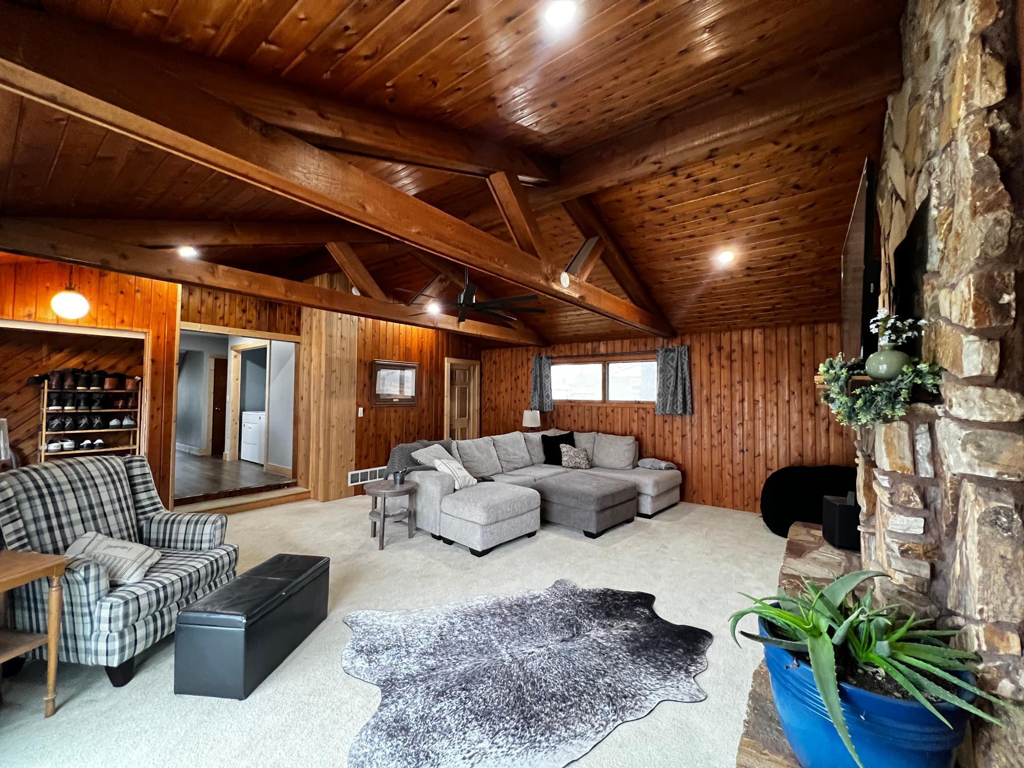 View of the Living Room with door to main floor full bathroom and hallway to the kitchen and laundry closet\.