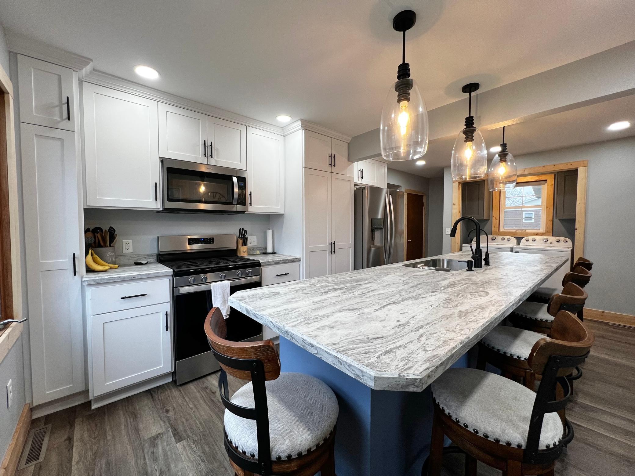 Stainless steel appliances compliment the white Cabinets and Countertops.