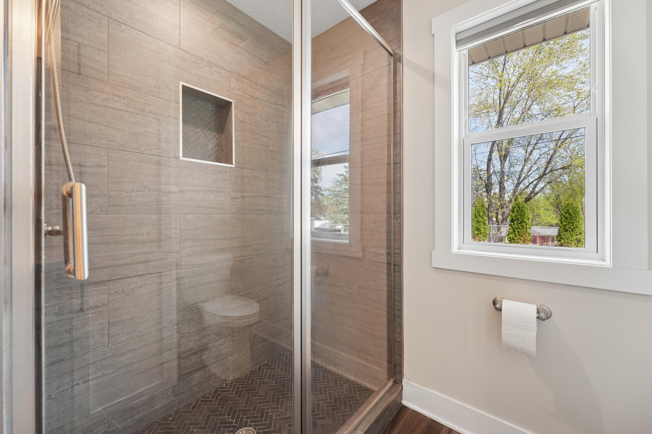 Tiled shower in primary bathroom