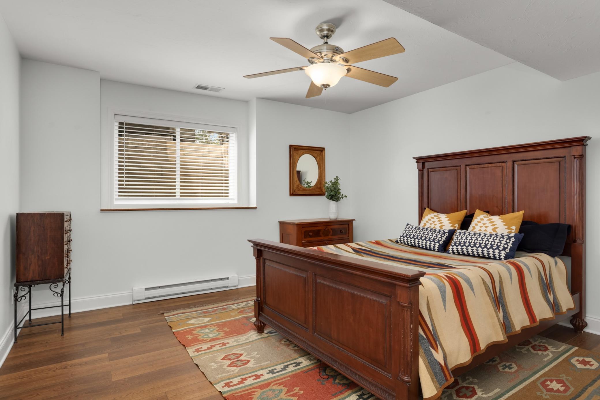 Lower-level bedroom with a window bringing in natural light.