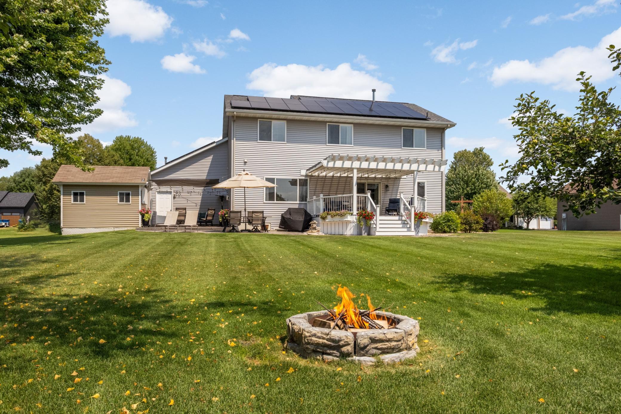 Everything you need for outdoor living: fire pit, storage shed, deck with pergola, paver patio & multiple seating and dining areas.