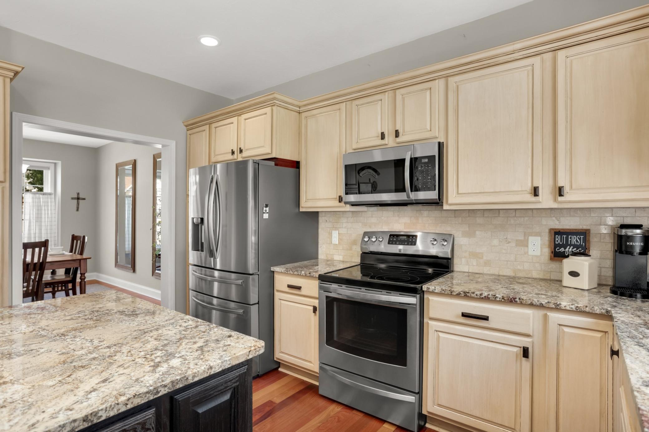 Kitchen boasts stainless steel appliances and flows seamlessly into the formal dining room.