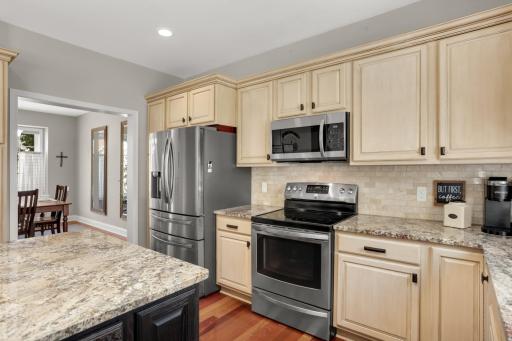 Kitchen boasts stainless steel appliances and flows seamlessly into the formal dining room.