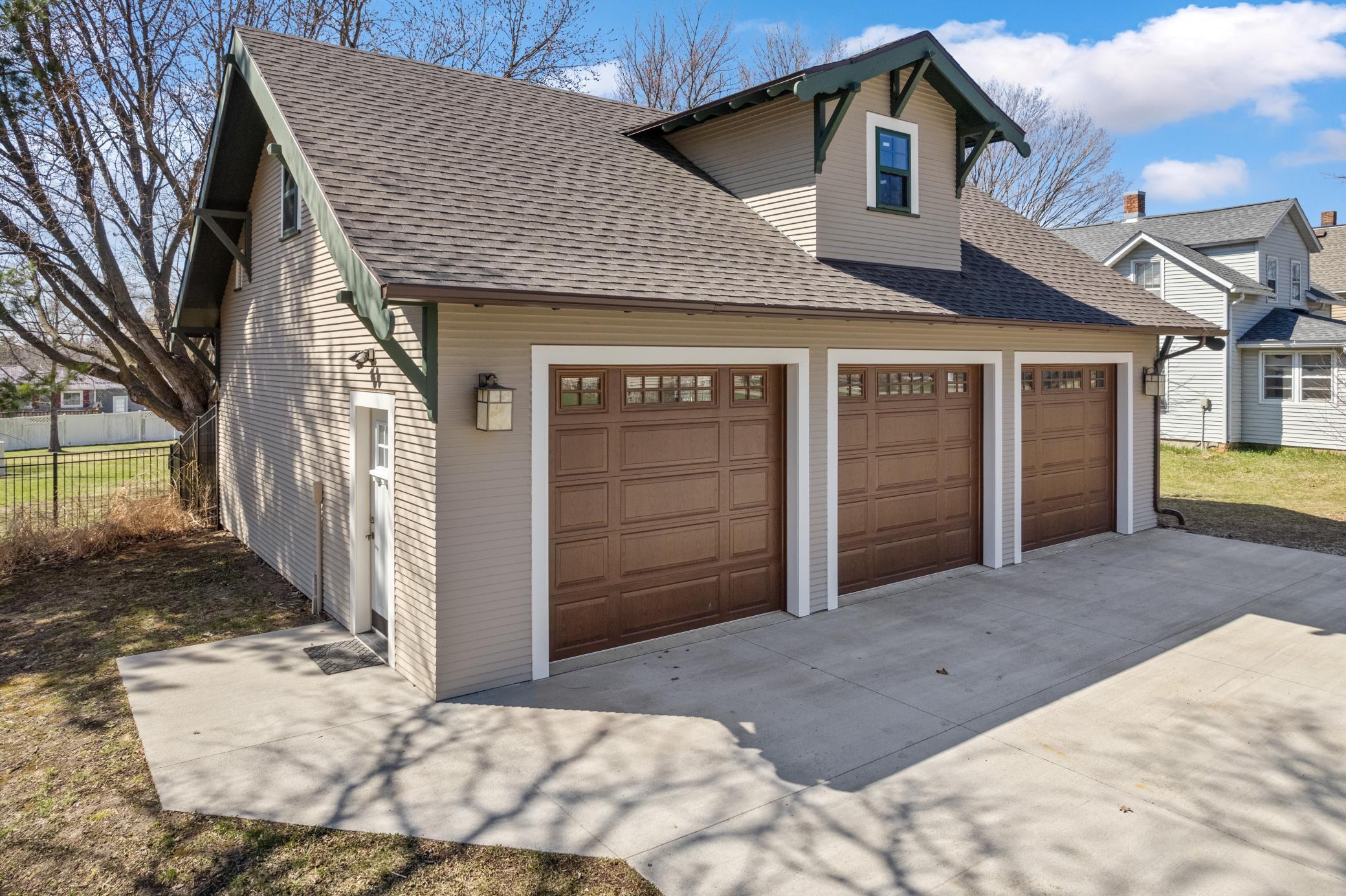 A large heated garage with air conditioning, surround sound, a projector screen, and a walk up attic