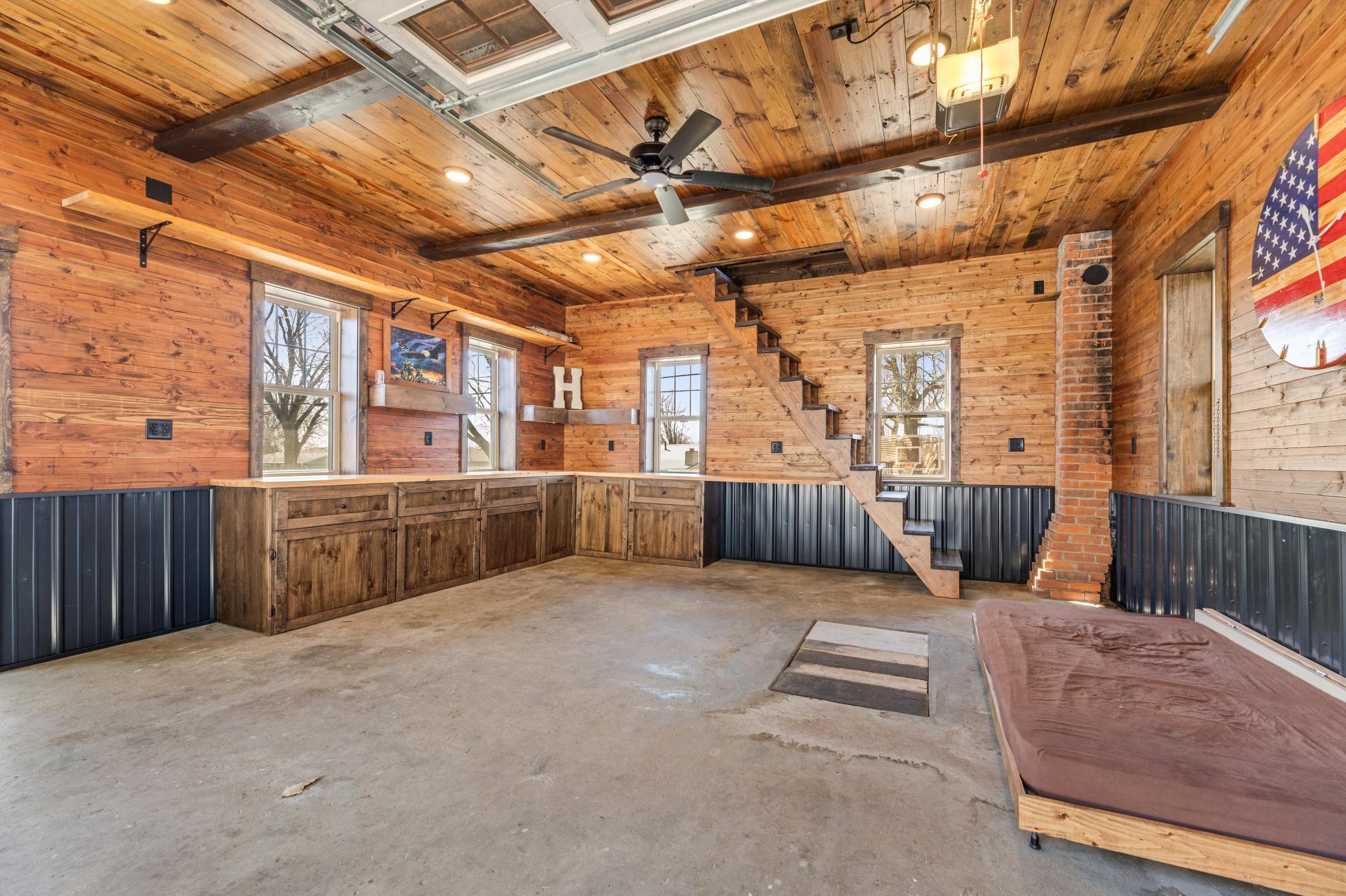 A large heated garage with air conditioning, surround sound, a projector screen, and a walk up attic