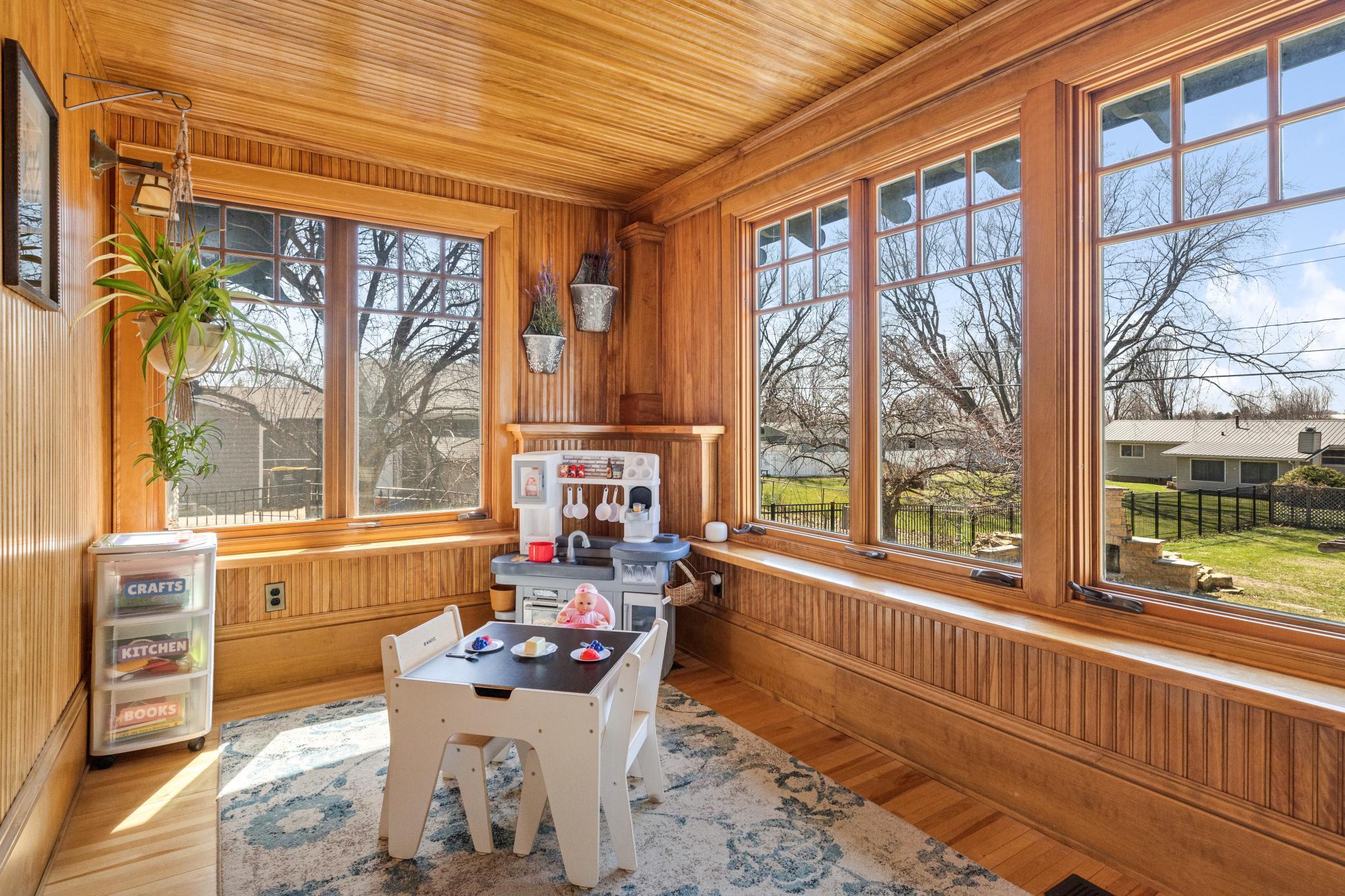 Sun-drenched sunroom with an adorable slanted wood ceiling that brings warmth and character to every season.