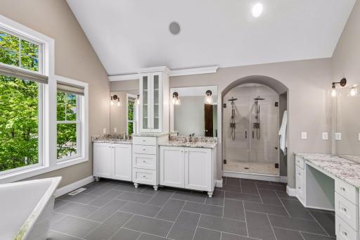 Huge private primary bath with vaulted ceilings, step in shower and dual sinks