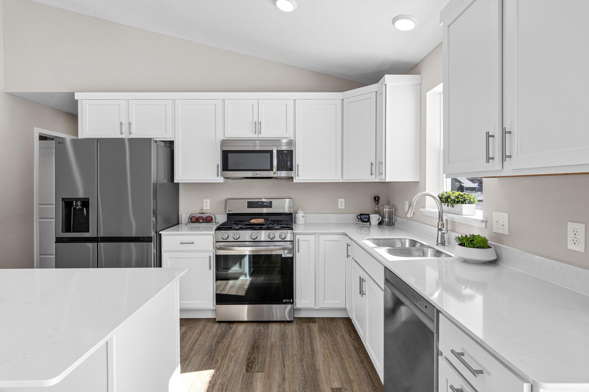 VIRTUALLY STAGED PHOTO OF A DIFFERENT HOME WITH SIMILAR PLAN & FINISHES. Kitchen. Photo may not depict actual plan, material, & finishes included in this home.