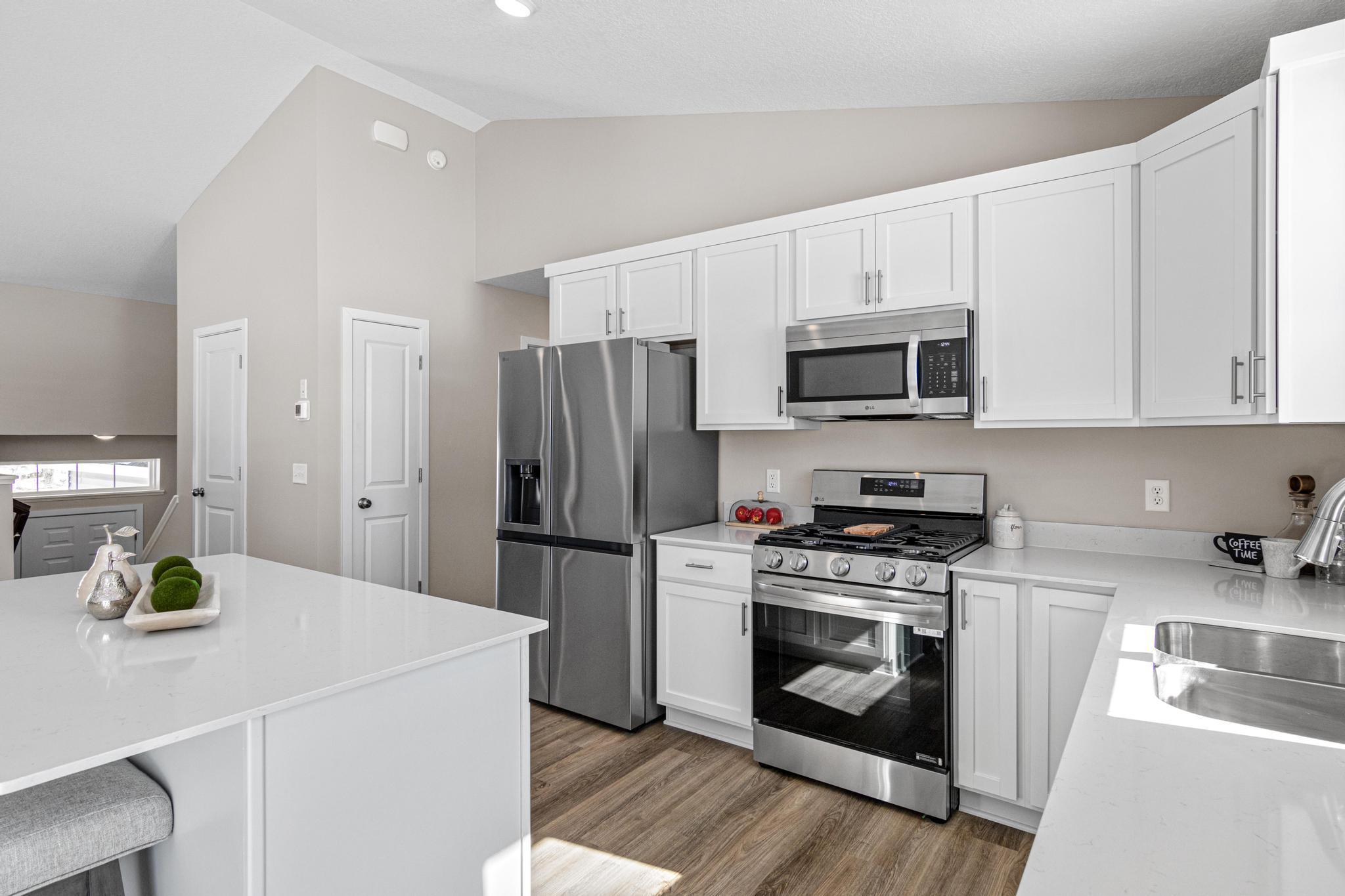 VIRTUALLY STAGED PHOTO OF A DIFFERENT HOME WITH SIMILAR PLAN & FINISHES. Kitchen. Photo may not depict actual plan, material, & finishes included in this home.
