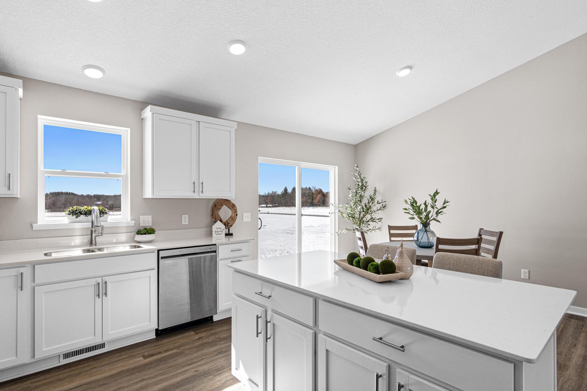 VIRTUALLY STAGED PHOTO OF A DIFFERENT HOME WITH SIMILAR PLAN & FINISHES. Kitchen and Dining Room. Photo may not depict actual plan, material, & finishes included in this home.