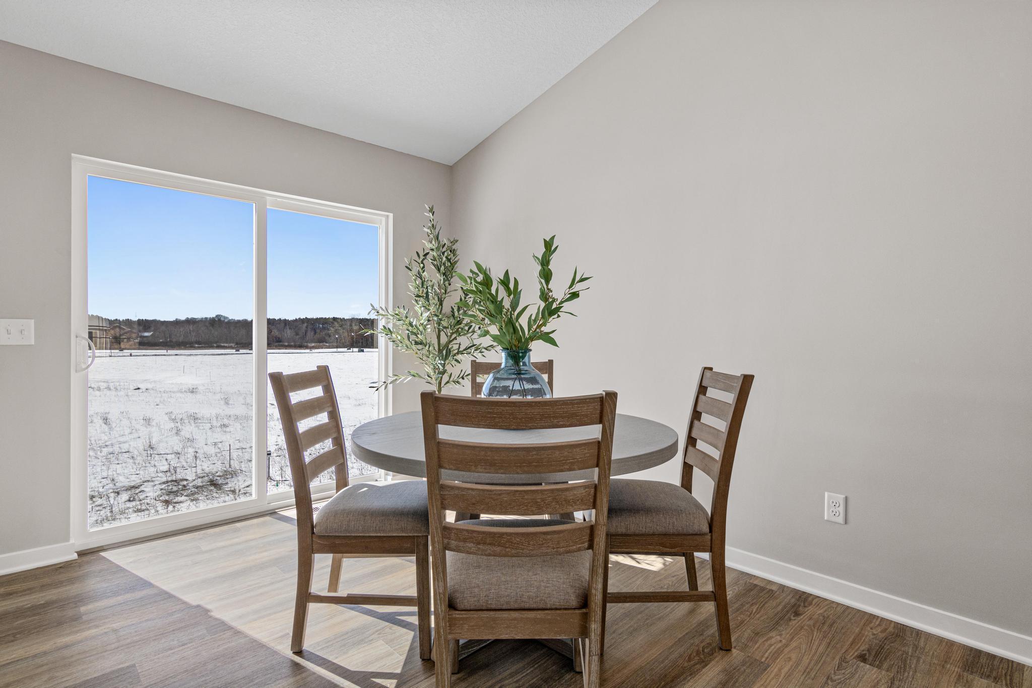 VIRTUALLY STAGED PHOTO OF A DIFFERENT HOME WITH SIMILAR PLAN & FINISHES. Dining Room. Photo may not depict actual plan, material, & finishes included in this home.