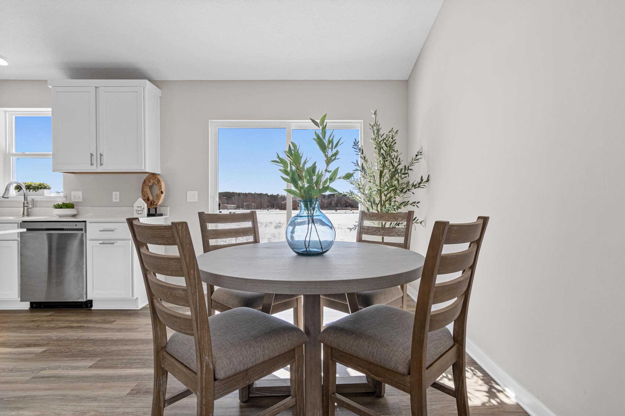 VIRTUALLY STAGED PHOTO OF A DIFFERENT HOME WITH SIMILAR PLAN & FINISHES. Dining Room. Photo may not depict actual plan, material, & finishes included in this home.
