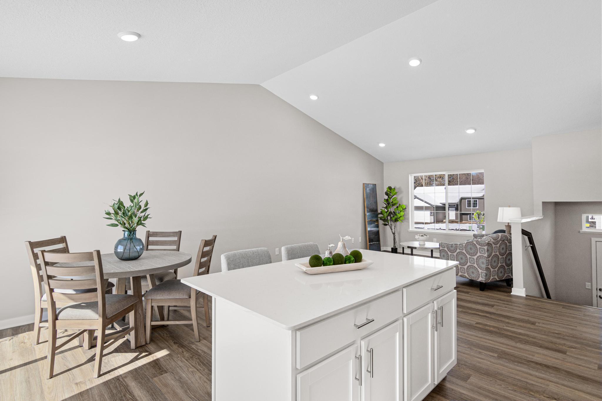 VIRTUALLY STAGED PHOTO OF A DIFFERENT HOME WITH SIMILAR PLAN & FINISHES. Kitchen open to Dining & Great Rooms. Photo may not depict actual plan, material, & finishes included in this home.