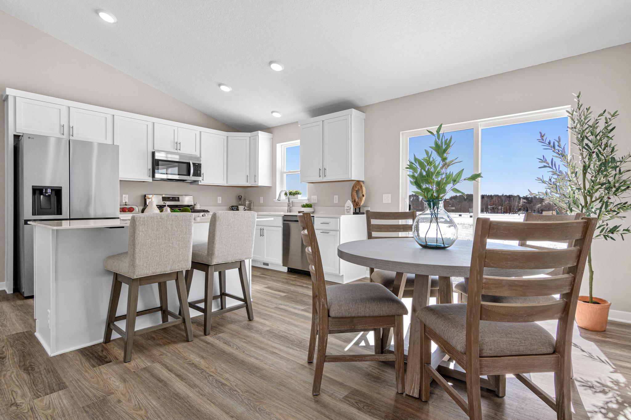 VIRTUALLY STAGED PHOTO OF A DIFFERENT HOME WITH SIMILAR PLAN & FINISHES. Kitchen and Dining Room. Photo may not depict actual plan, material, & finishes included in this home.
