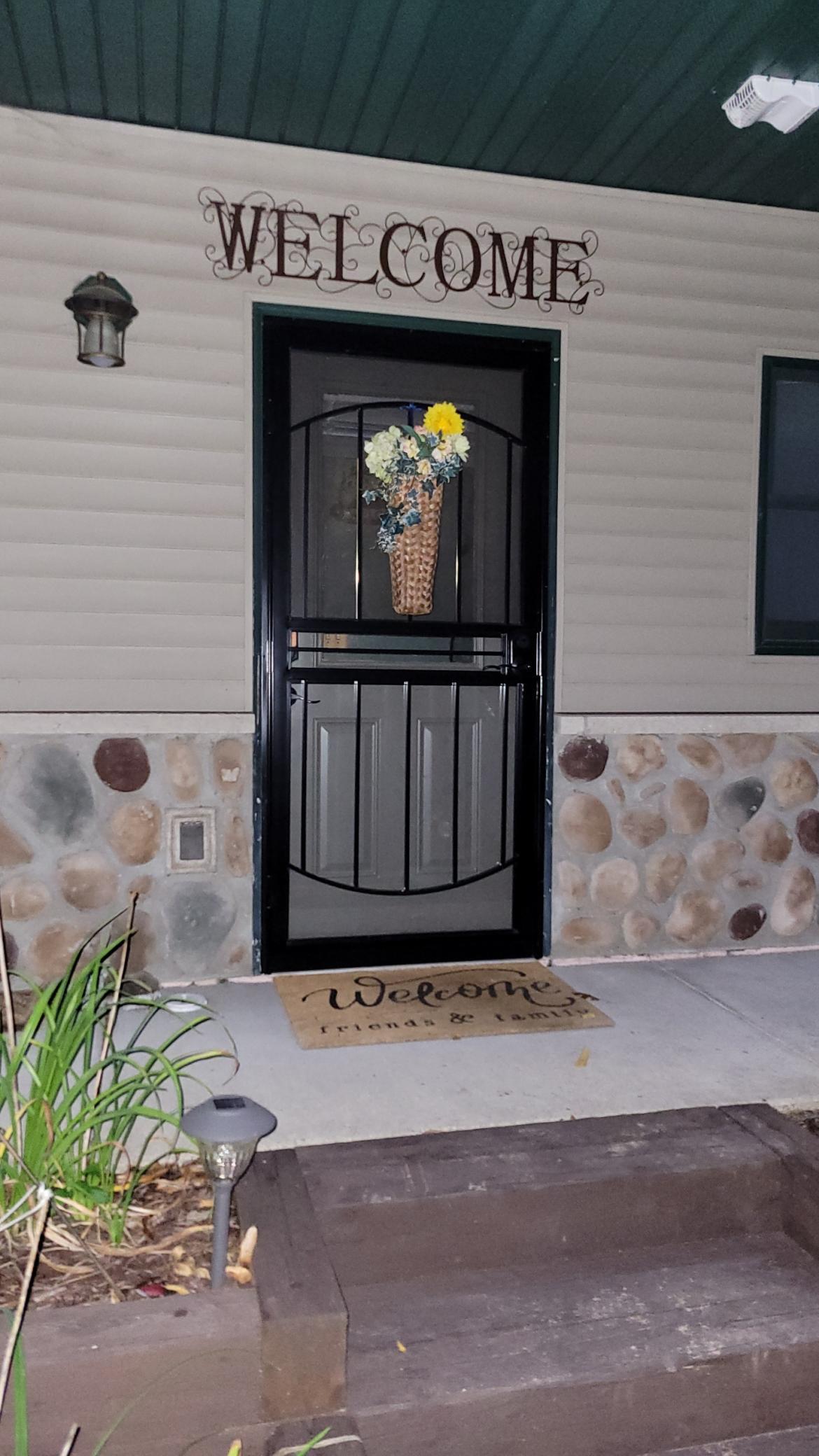 Overhang covers the entrance and sidewalk of the home