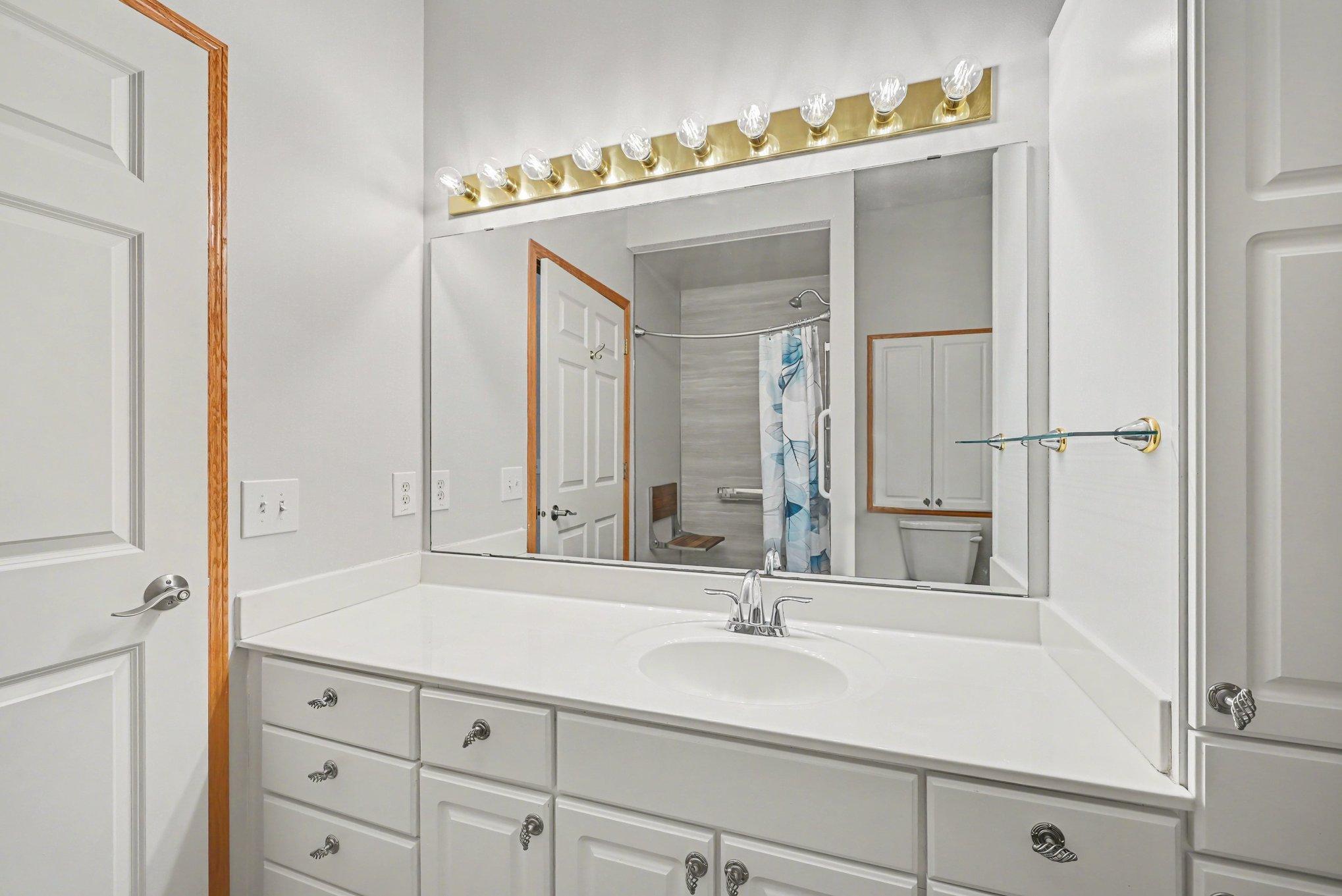 Look closely in mirror. Large primary bathroom with custom walk in shower with bench.