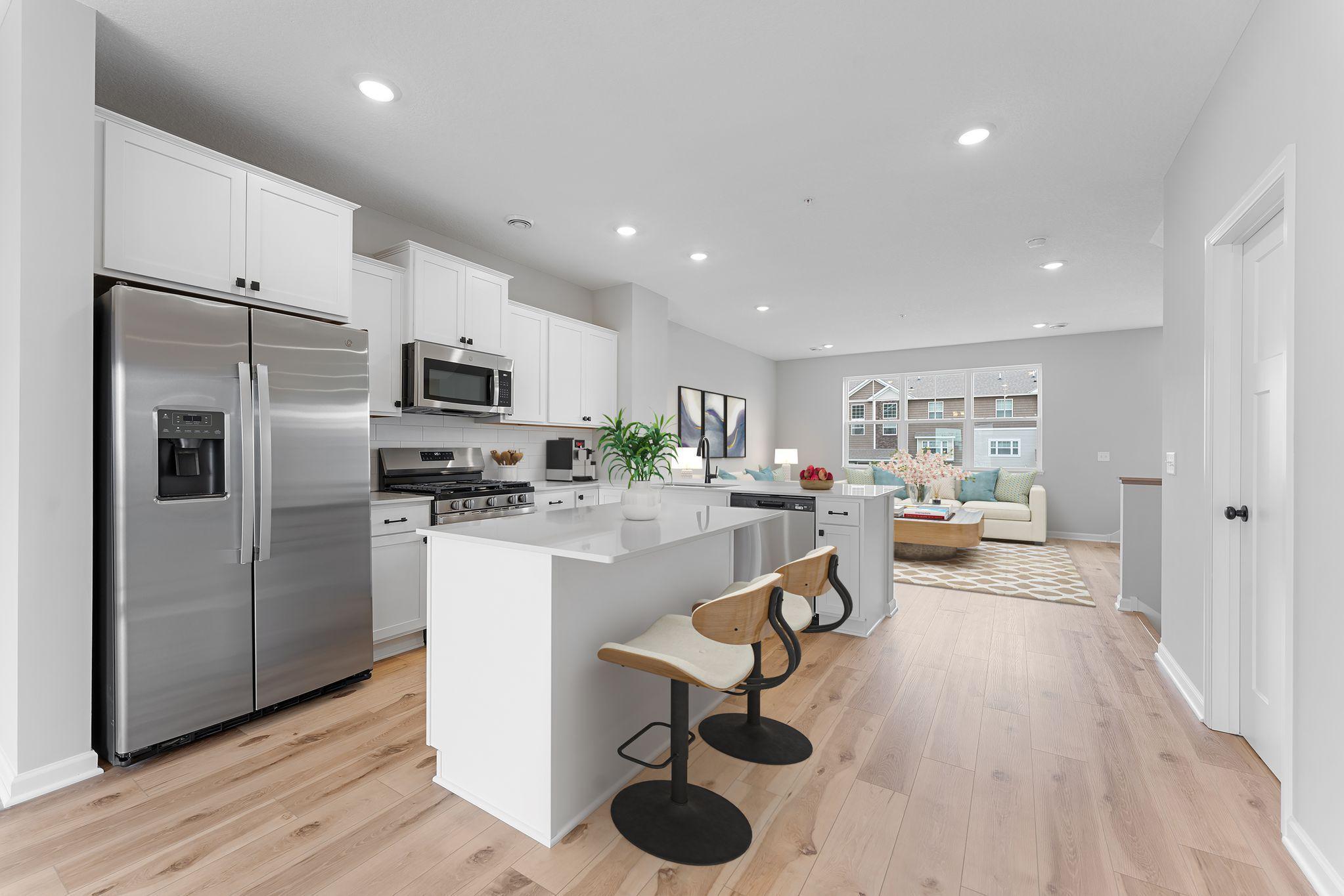 Offering timeless finishes that blend an elevated feel with functionality. The L-shaped kitchen with island and adjacent dining area make a perfect space for both everyday meals and entertaining. Similar home shown, color & finish can vary.
