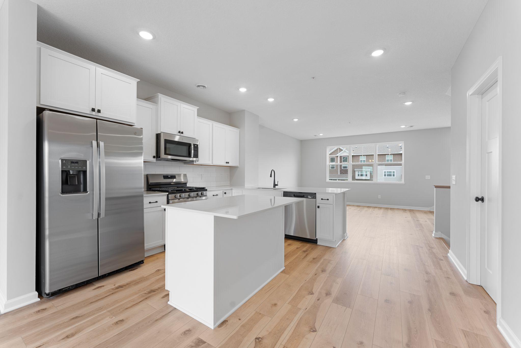 The island provides additional seating, storage and surface space. Similar home shown, color & finish can vary.