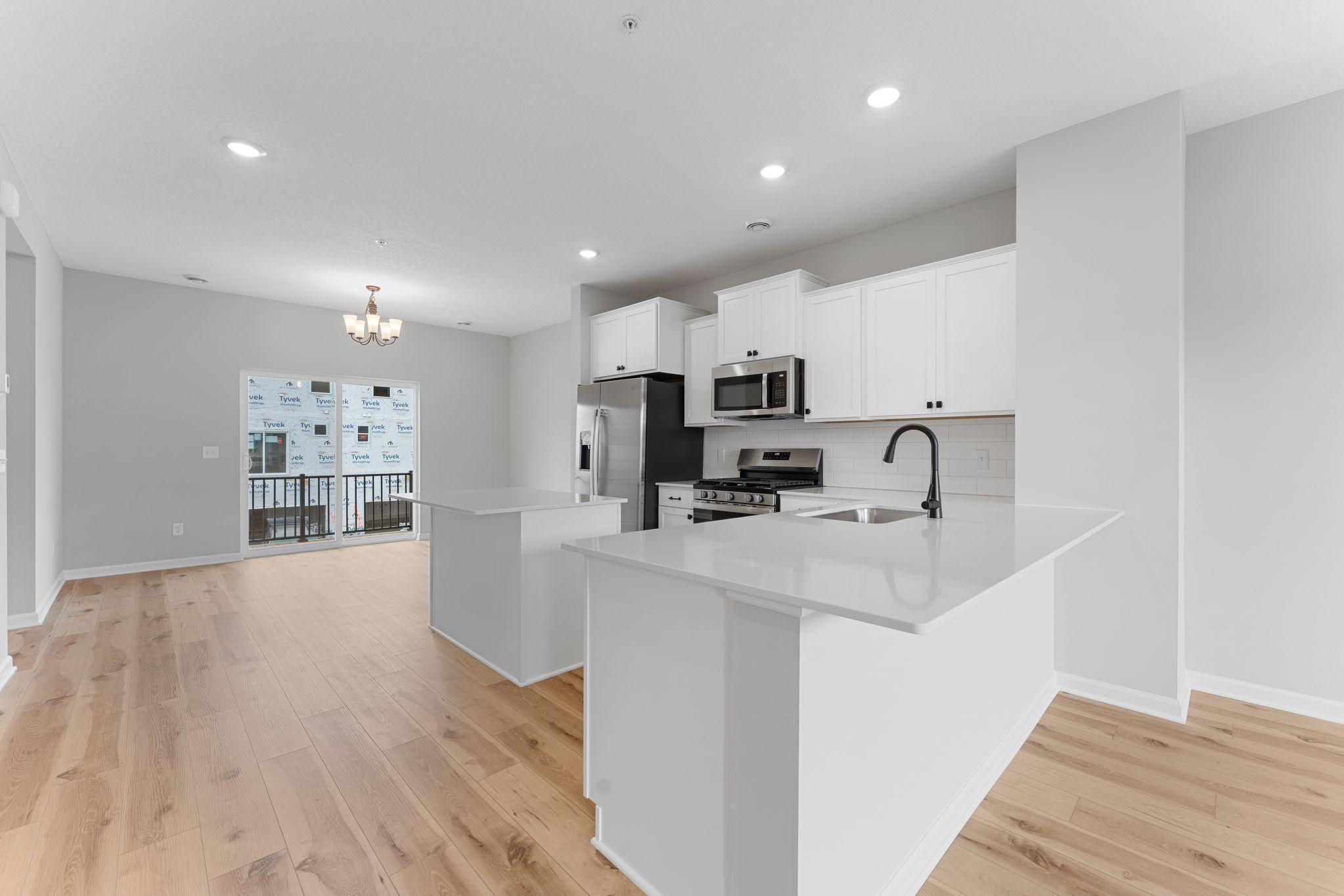 This L-shaped kitchen provides an optimal flow with a breakfast bar for added seating. The dedicated dining space is tucked away from the family room for that optimal layout you're looking for. Similar home shown, color & finish can vary.