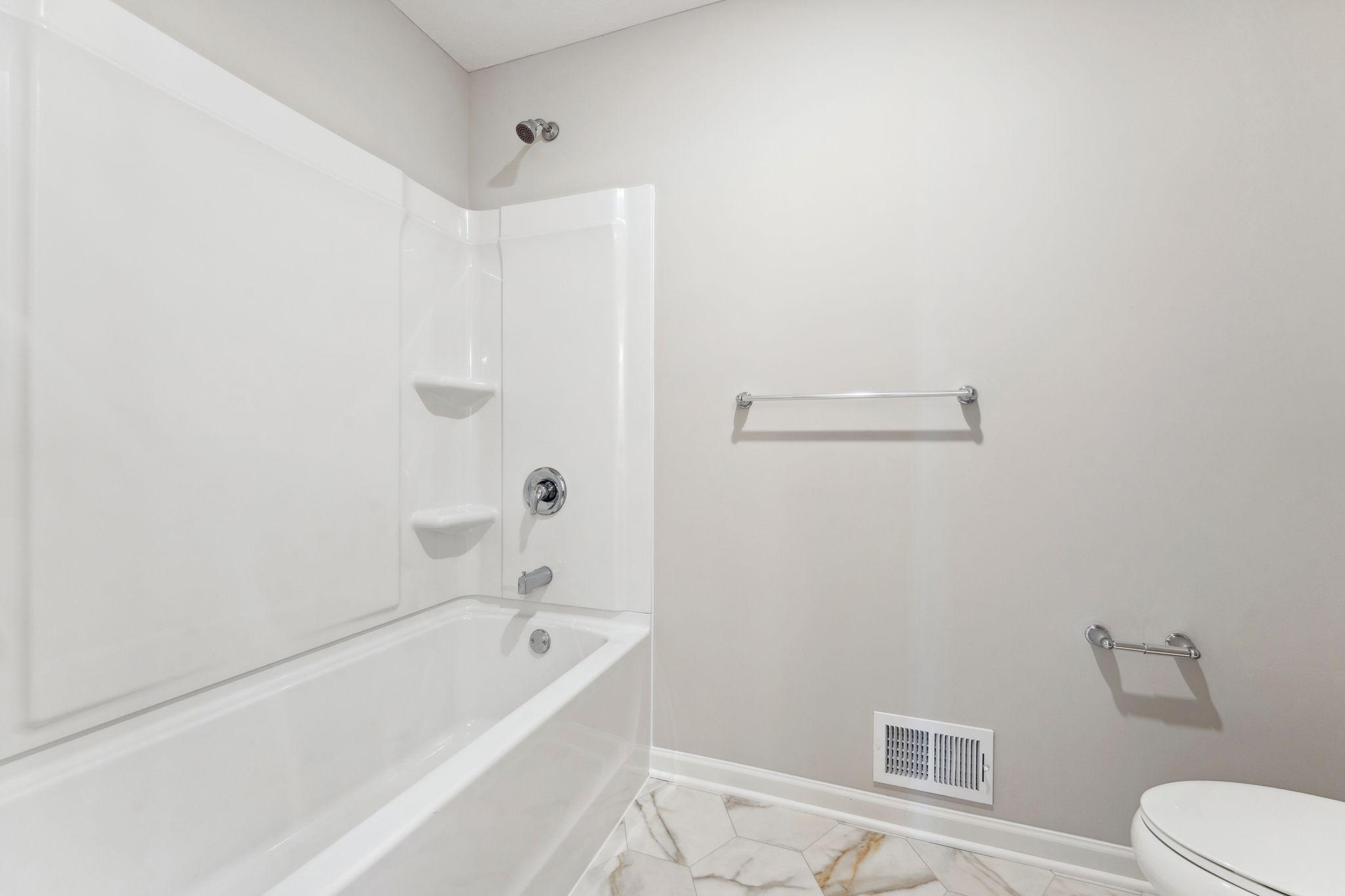 Main level shower/tub. Similar home shown, color & finish can vary.