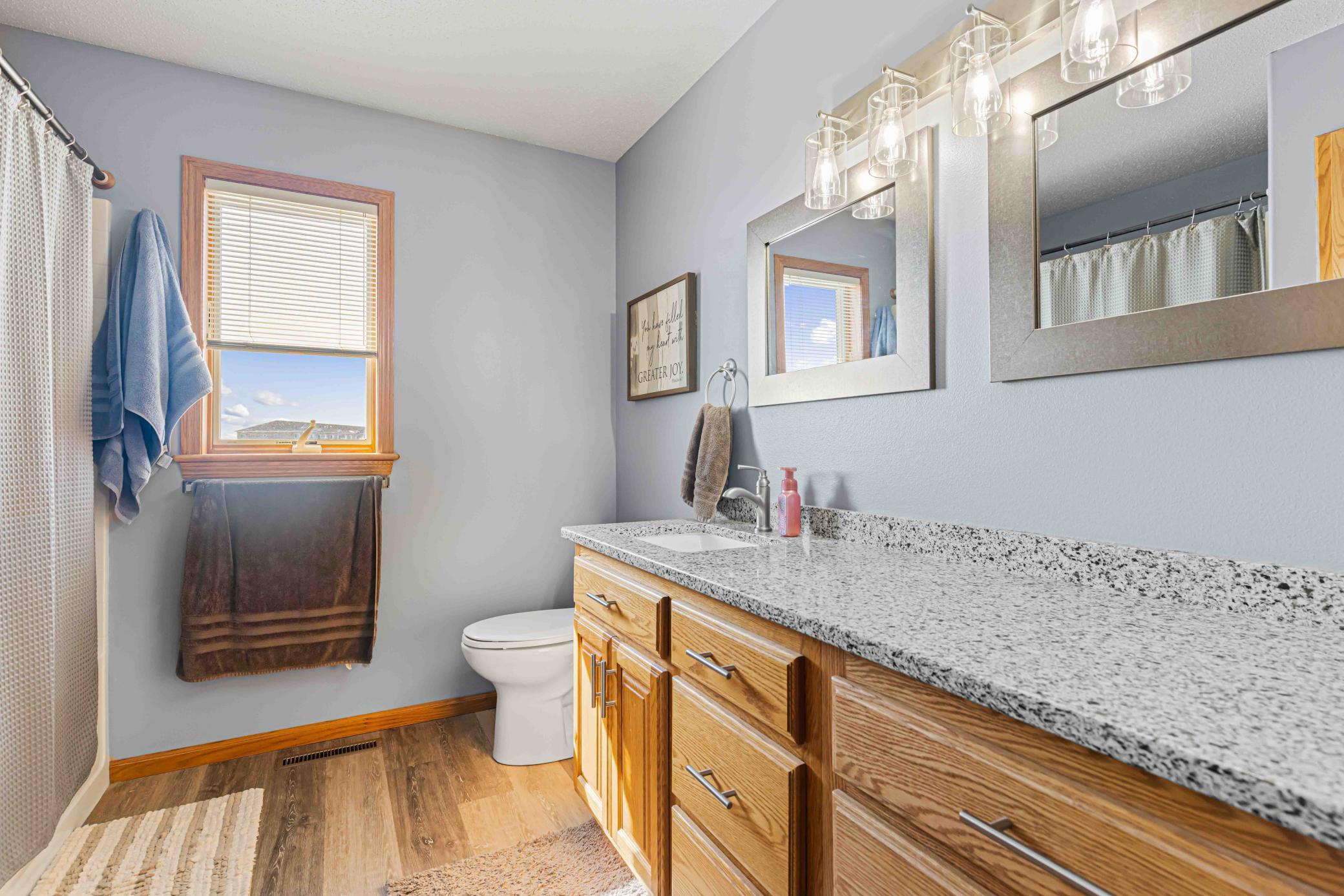 Full bathroom with quartz counter tops, luxury vinyl plank flooring,