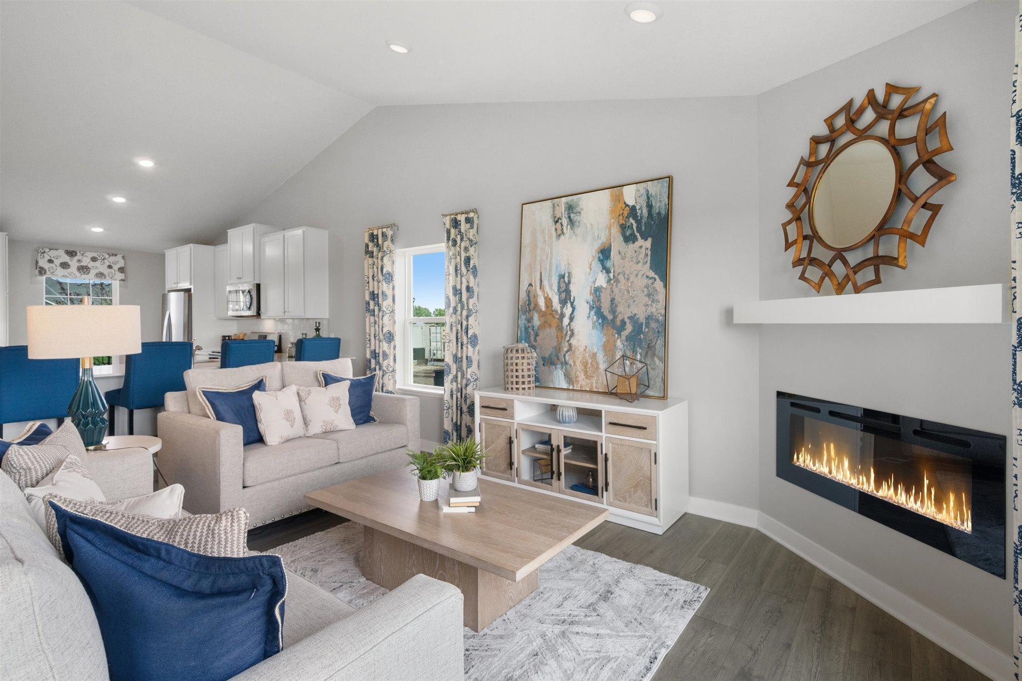 Open concept living with a modern electric fireplace. Our smart home package is included in every home. Photo is of model home. Colors and options may vary. Ask Sales Agent for details.