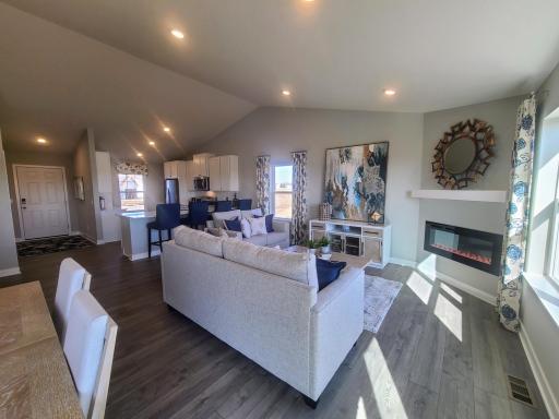 Open concept living with a modern electric fireplace. Our smart home package is included in every home. Photo is of model home. Colors and options may vary. Ask Sales Agent for details.