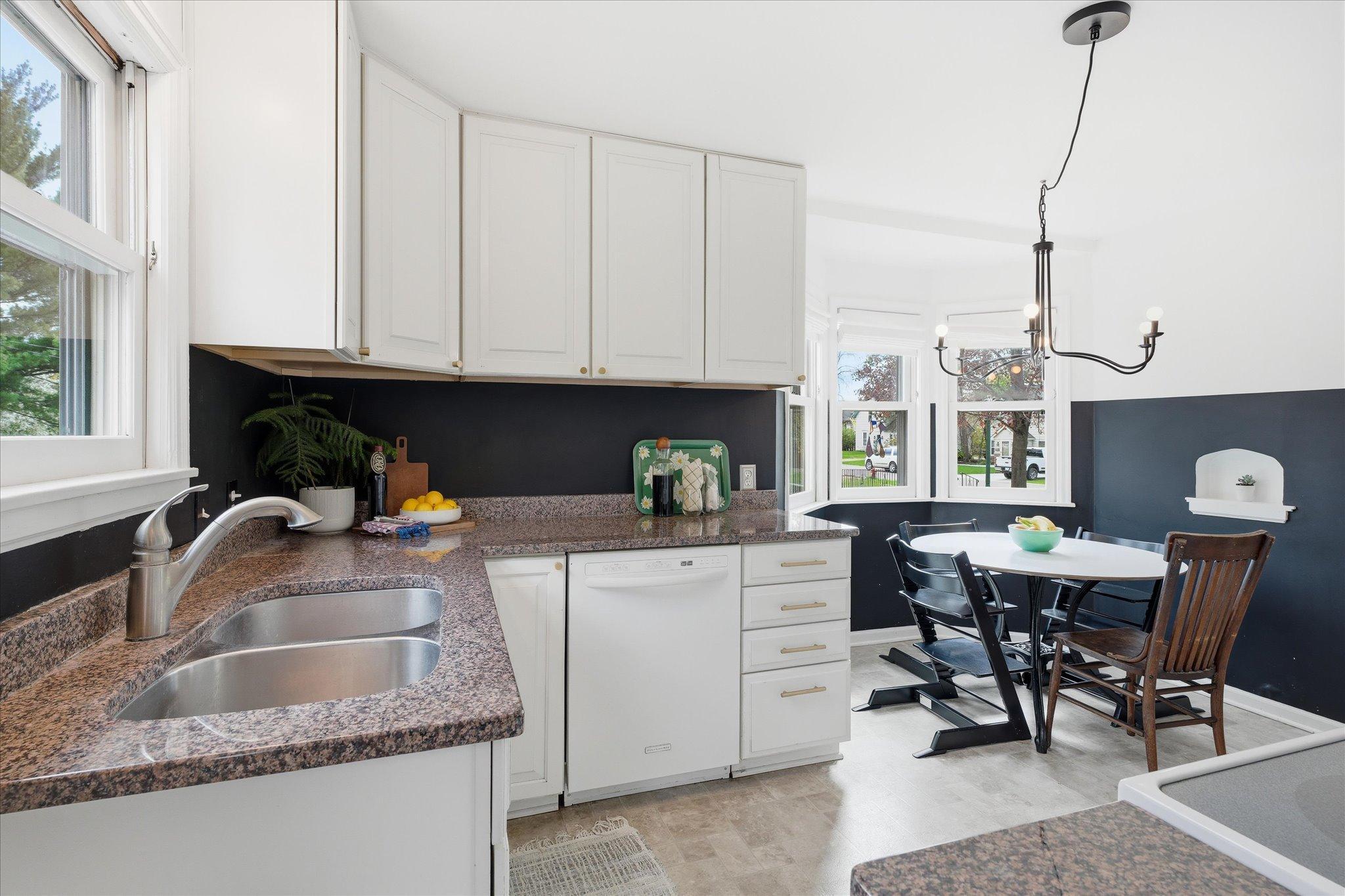 The dual basin stainless steel sink and single-lever nickel faucet add to the modernizing effect of the gold cabinet pulls. :)