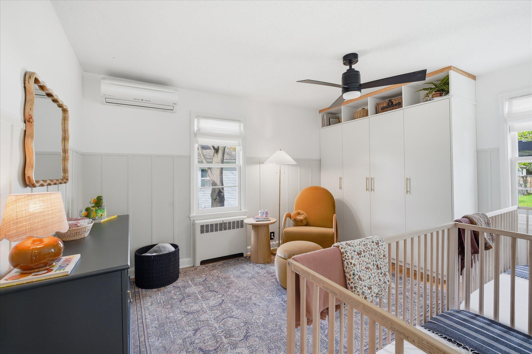 The main level bedroom features a custom closet system, a modern ceiling fan, Marvin windows, and a mini-split AC unit.