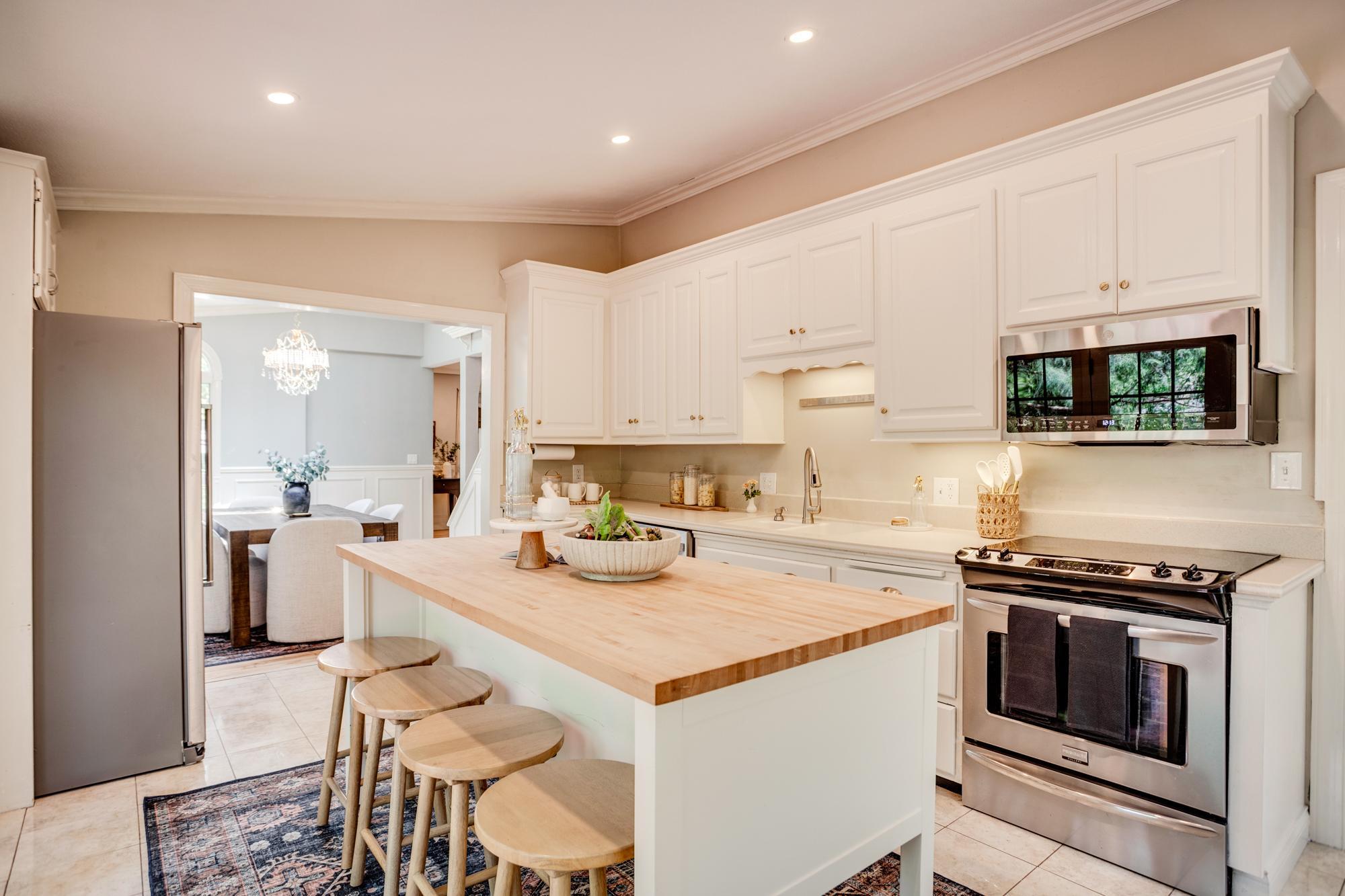 The kitchen features a center island, breakfast bar, eat-in dining area, and bay window.